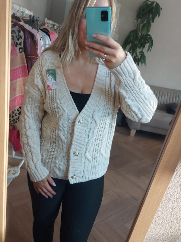 Beige gebreid vest met kabelpatroon en knopen